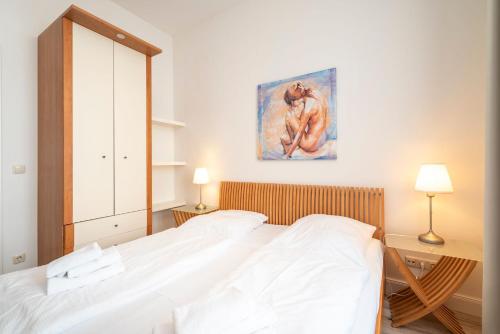 a bedroom with a bed and a painting on the wall at Villa Frohsinn Appartement 09 in Bansin