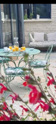 a table and chairs with drinks on a patio at Les Glycines de Monchy- Chambres d'hôtes in Monchy-Humières
