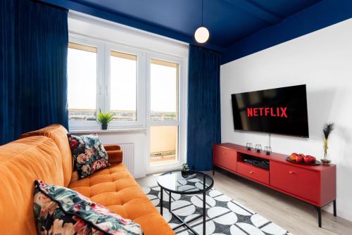 a living room with a couch and a television at Kairos Apartments - Gwarek - darmowy parking, ścisłe centrum in Katowice