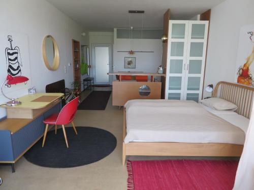 1 dormitorio con cama, escritorio y cocina en Studio-Apartment en Trausdorf an der Wulka