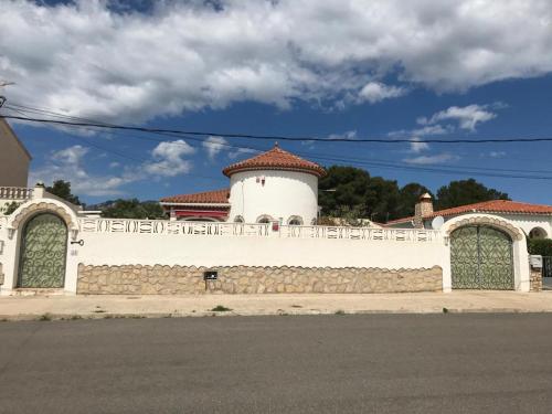 a white building with a fence on a street at Mooie vrijstaande vakantiewoning met privé-zwembad in Miami Platja