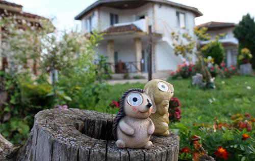 two toy animals sitting on top of a tree stump at Къща за гости Света Марина in Krapets