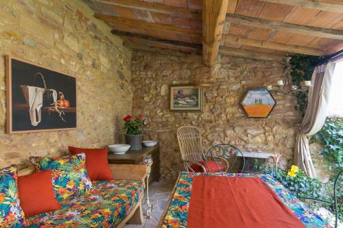 ein Wohnzimmer mit einem Sofa und einer Steinmauer in der Unterkunft La Stallina in Sant'Ermo