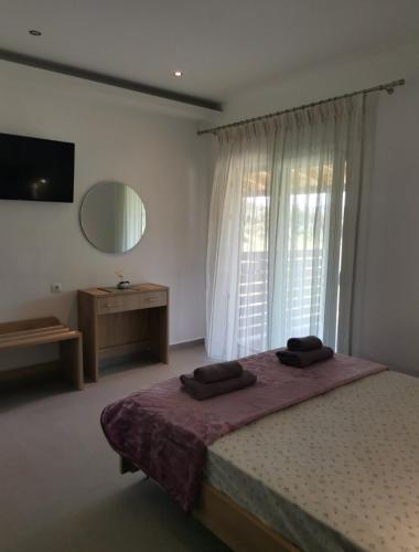 a bedroom with a bed and a large window at CASA QUERCU in Sykia Chalkidikis