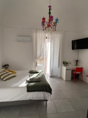 um quarto com uma cama e um lustre em CiuriCiuri Home Appartamento storico nel centro di Catania em Catânia