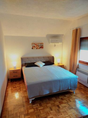 a bedroom with a bed with two night stands and a window at Holiday Home Mirza in Sarajevo