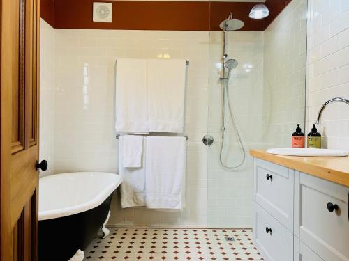 a bathroom with a shower and a tub and a sink at Willunga Gallery Cabins in Willunga