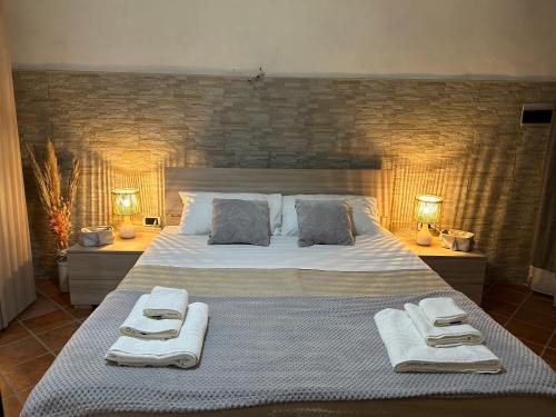 1 dormitorio con 1 cama grande y toallas. en Sun Garden Home en Somma Vesuviana