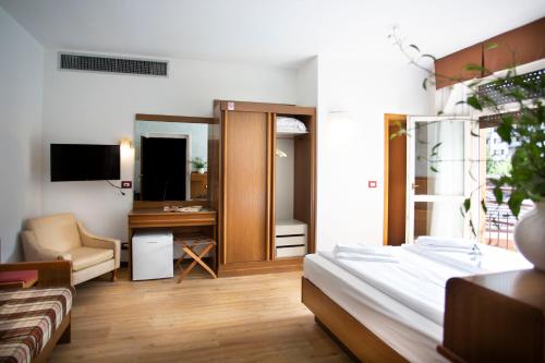 a bedroom with a bed and a living room at SunLake Hotel in Riva del Garda