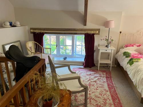 a bedroom with a bed and a table and a window at Bradford Mill in Tiverton