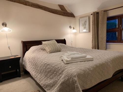 ein Schlafzimmer mit einem Bett mit zwei Handtüchern darauf in der Unterkunft The Byre in Abingdon