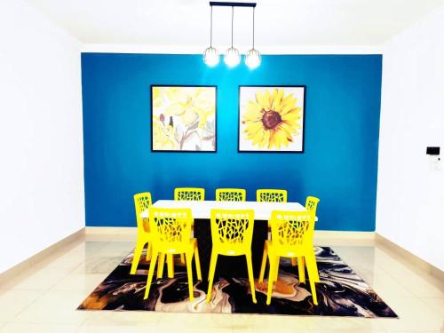 a dining room with a table and yellow chairs at EZHomestay Platinum near Cyberjaya Putrajaya KLIA in Kampung Dengkil