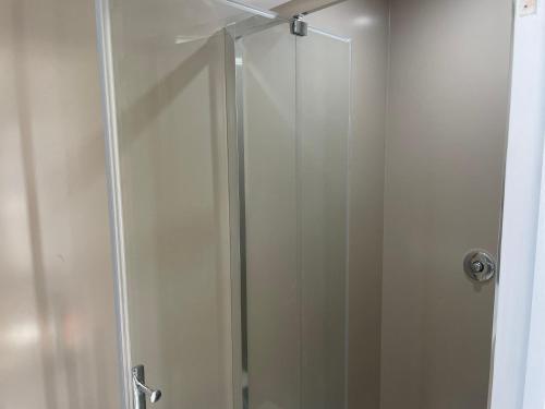 a shower with a glass door in a bathroom at Wayfarers Inn in Penzance