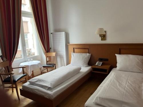 um quarto de hotel com duas camas e uma janela em Hotel Römischer Kaiser em Trier