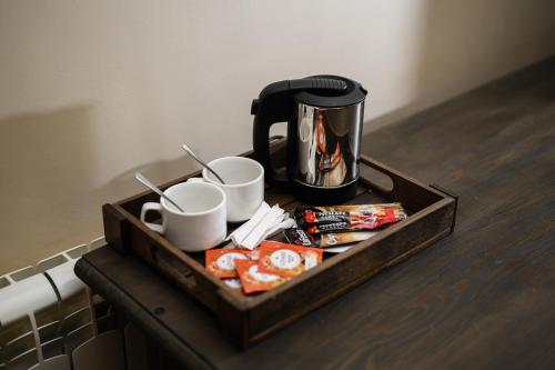 a tray with cups and coffee cups on a table at Bogolvar Retreat Resort in Antonovka