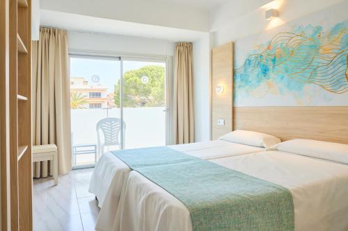 Cette chambre comprend un lit et une grande fenêtre. dans l'établissement Hostal Gami Adults Only, à Cala Ratjada