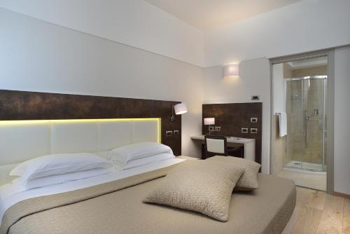 a bedroom with a large bed and a desk at Hotel Bologna Airport in Bologna