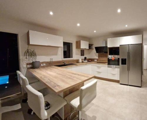a kitchen with a wooden table and white appliances at Nice, Magnifique villa vue mer avec piscine in Nice