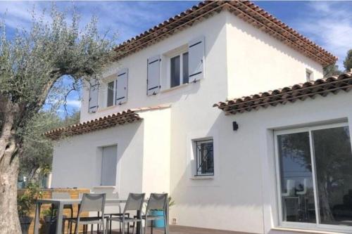 a white house with a table and chairs at Nice, Magnifique villa vue mer avec piscine in Nice