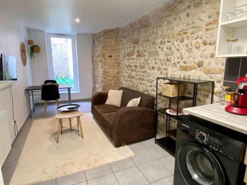 ein Wohnzimmer mit einem Sofa und einem Tisch in der Unterkunft Vaste Appartement Rénové - Centre Ville in Bourg-en-Bresse
