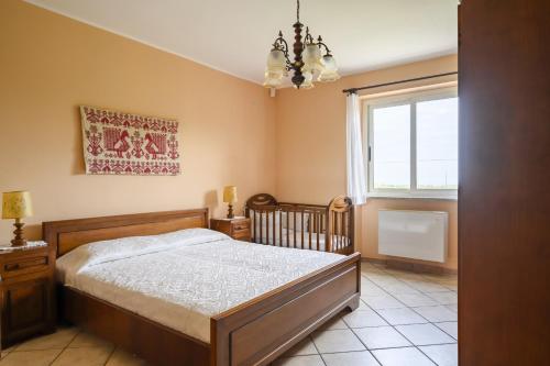 Schlafzimmer mit einem Bett und einem Fenster in der Unterkunft La Collina degli Ulivi in Bari Sardo