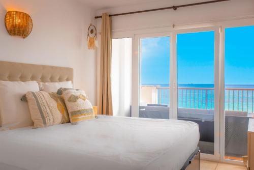 een slaapkamer met een bed en uitzicht op de oceaan bij Sea Front apartment in Ibiza-stad