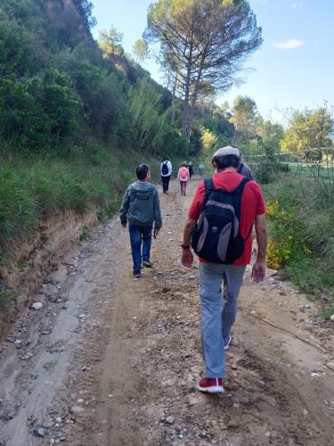 a group of people walking down a dirt road at L'Olivera Casa Rural in Castellbisbal