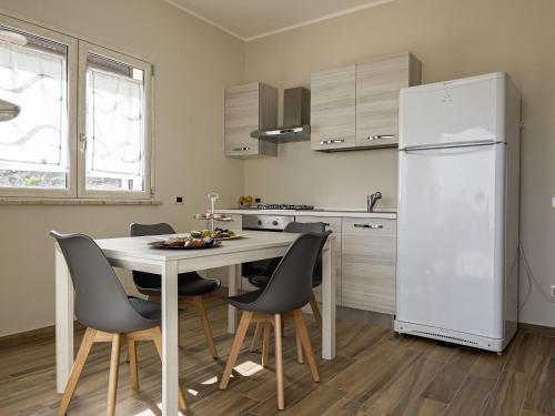 uma cozinha com uma mesa e cadeiras e um frigorífico em Athena Agrigento Apartments em Agrigento