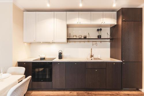 a kitchen with white cabinets and a sink at Pure Rental Apartments in Wrocław