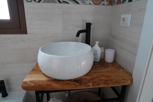 a white bowl sink on a wooden table in a bathroom at le casette in Aradeo