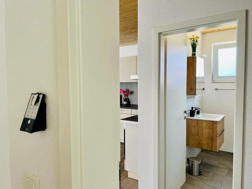 a door leading into a kitchen with a sink at GrenzApartments in Bietingen