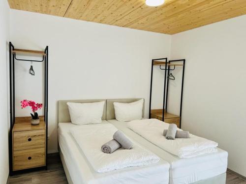 a bedroom with two beds with white sheets and pillows at GrenzApartments in Bietingen