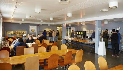 um restaurante com pessoas sentadas em torno de mesas e cadeiras em Hardanger Hostel B&B em Lofthus