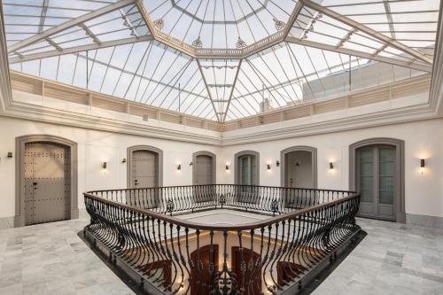 a large lobby with a glass ceiling and a staircase at Áurea Casa Palacio Sagasta by Eurostars Hotel Company in Cádiz