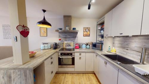 une cuisine avec des armoires blanches et un comptoir en bois dans l'établissement Zum Storike Nescht, à Barr