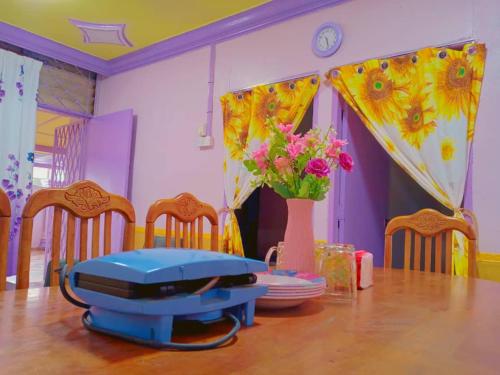 a dining room with a table and chairs with a suitcase at Gooday homestay in Skudai