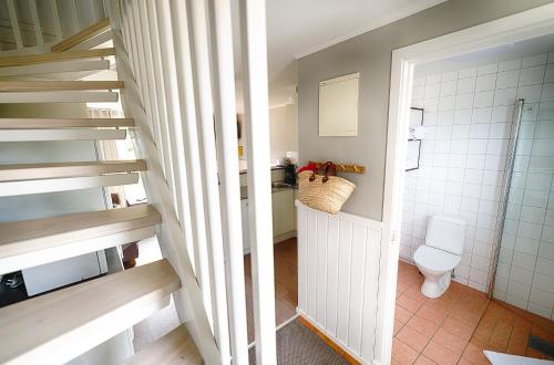 a bathroom with a staircase and a toilet in it at Apelviken Lägenhetshotell in Varberg