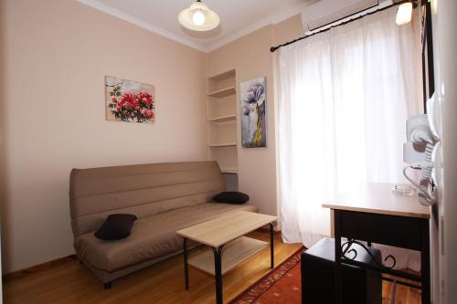 a living room with a couch and a table at Lefcothea Guest Rooms in Lákka