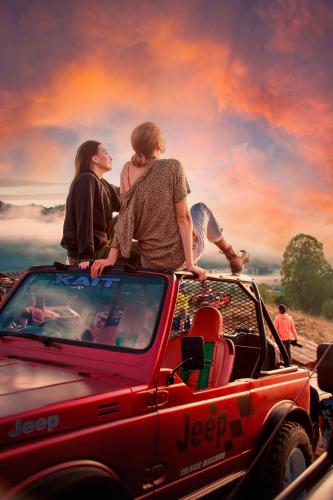 three people sitting on the back of a truck at Batur Green Hill and Hot Spring in Kintamani