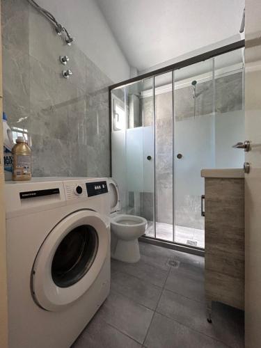 a bathroom with a washing machine and a toilet at Maria's maisonette Nea Iraklitsa in Iraklitsa