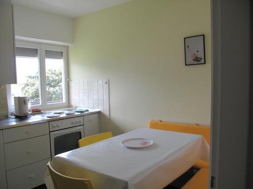 a kitchen with a table and a white table and chairs at Casa Foletta in Cugnasco