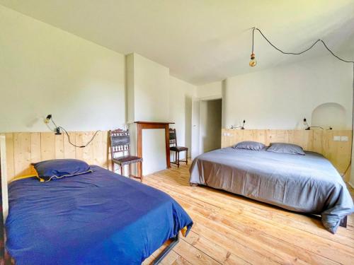 a bedroom with a large bed and a wooden floor at La vieille ferme de Gaillac in Gaillac