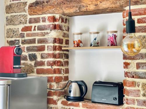 a kitchen with a brick wall with a toaster and a microwave at La vieille ferme de Gaillac in Gaillac