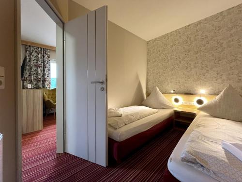 a bedroom with two beds and a sliding door at Familienhotel "Rhön Feeling" in Bernshausen