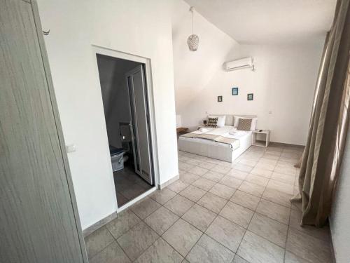 a white room with a bed and a mirror at Vila Ithea in 2 Mai