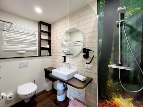 a bathroom with a shower and a sink and a mirror at Familienhotel "Rhön Feeling" in Bernshausen