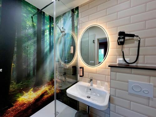 a bathroom with a sink and a glass shower at Familienhotel "Rhön Feeling" in Bernshausen