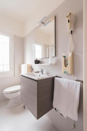 a bathroom with a sink and a toilet and a mirror at Hotel Villa Giada in Marina di Massa