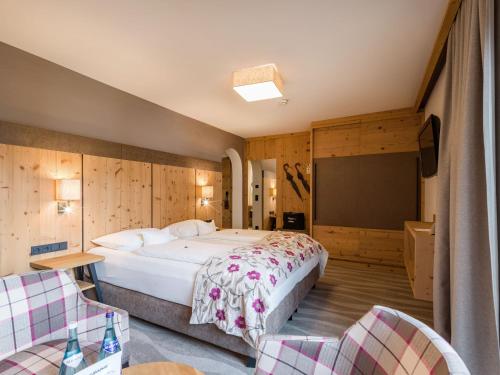 a bedroom with a large bed and a flat screen tv at Hotel & Spa Sonne 4 Sterne Superior in Kirchberg in Tirol