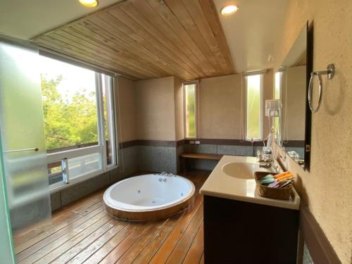 a bathroom with a large tub and a large window at Ailiga Travel Villa in Renai